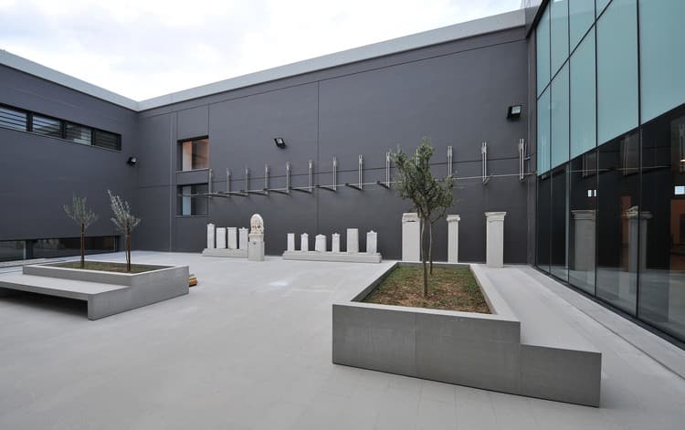 The central atrium courtyard with olive trees and ancient stelae