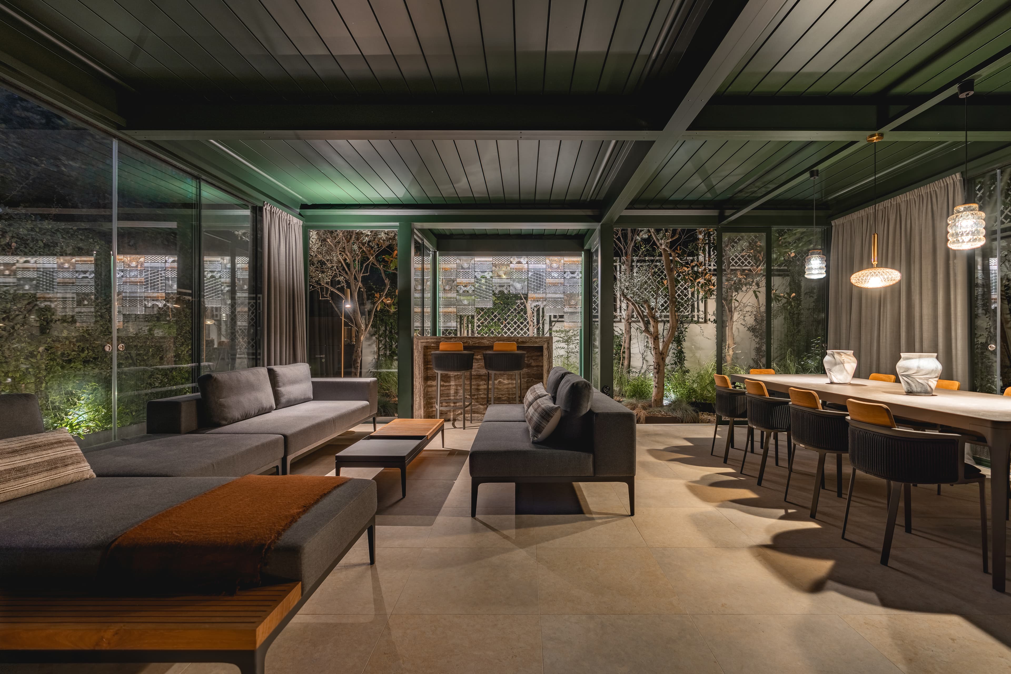 Inside the pavilion at night, lounge and dining aglow