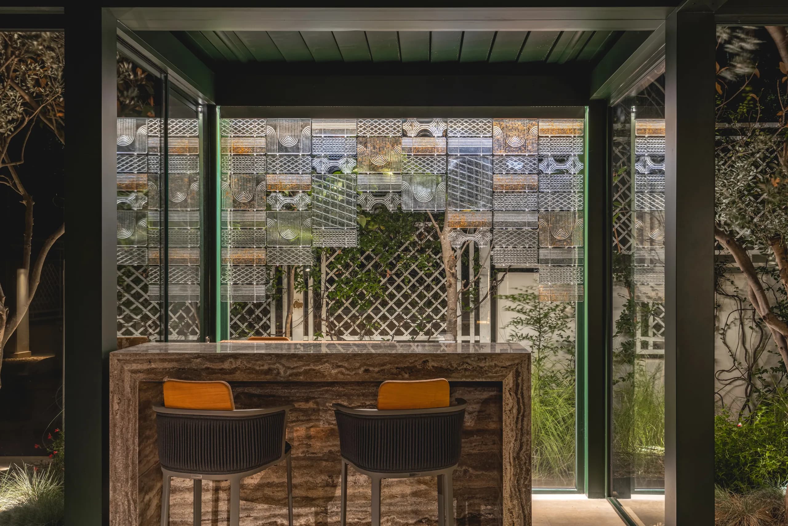 The travertine bar counter and colored-glass screen