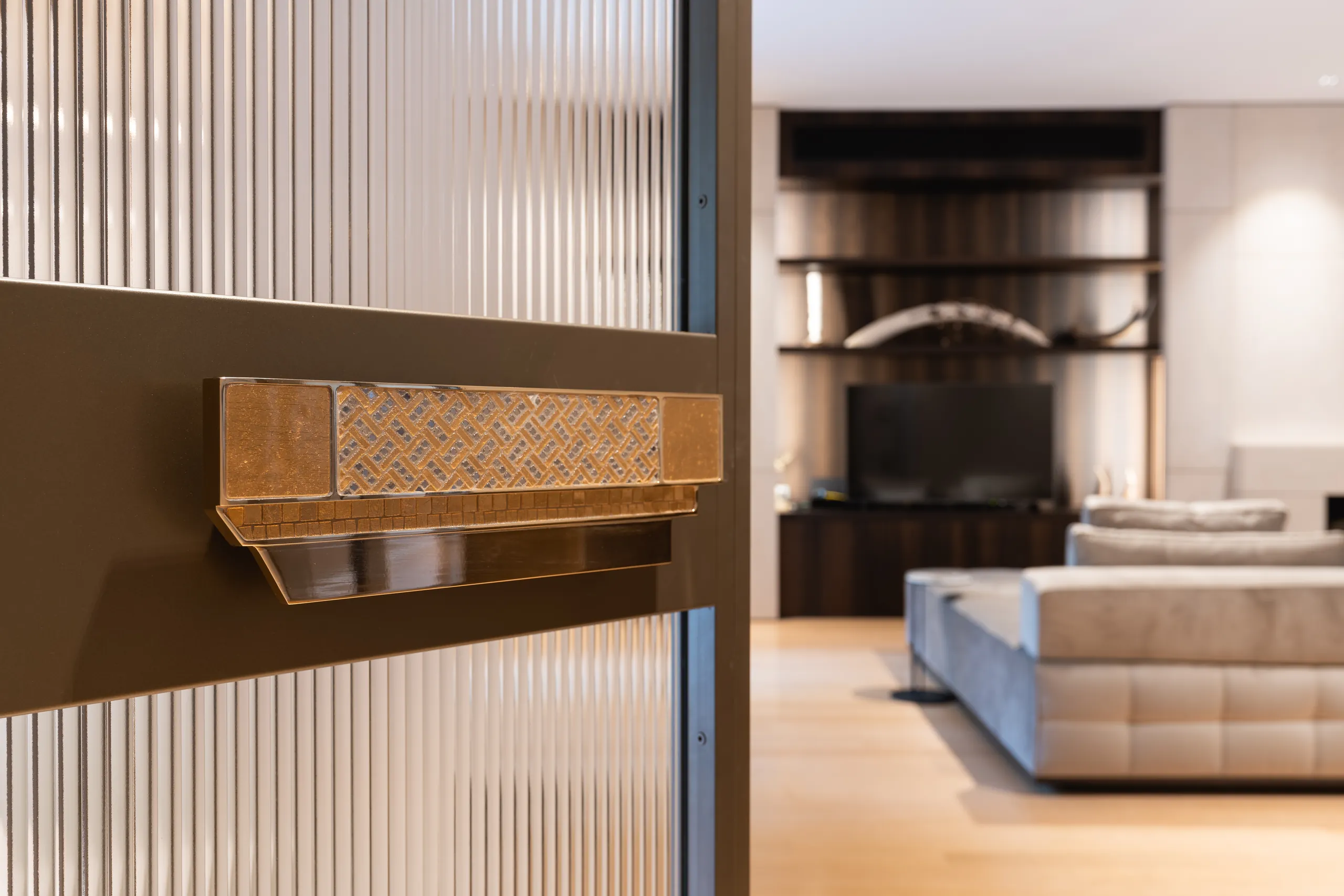 Woven brass door handle on ribbed glass