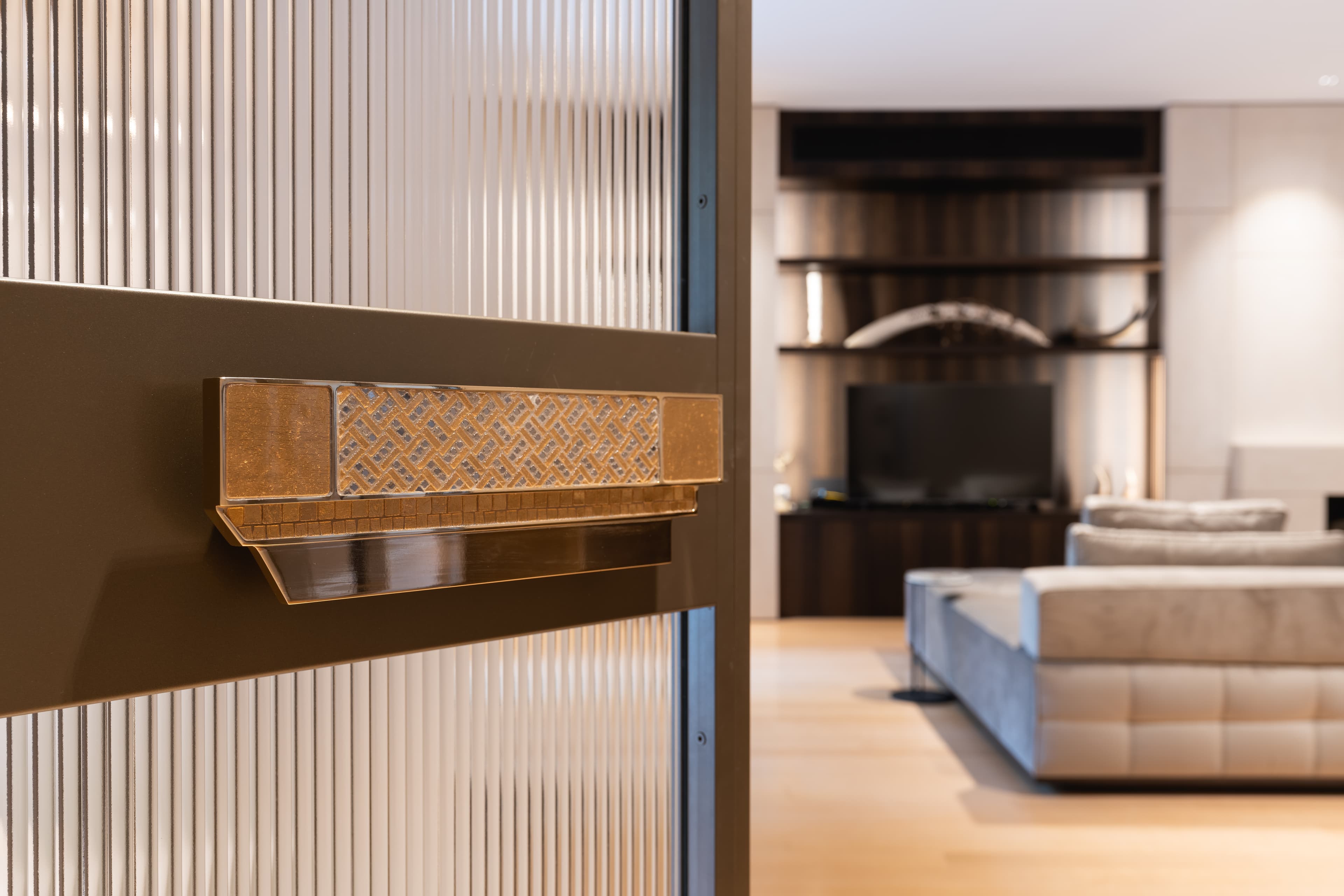 Woven brass door handle on ribbed glass