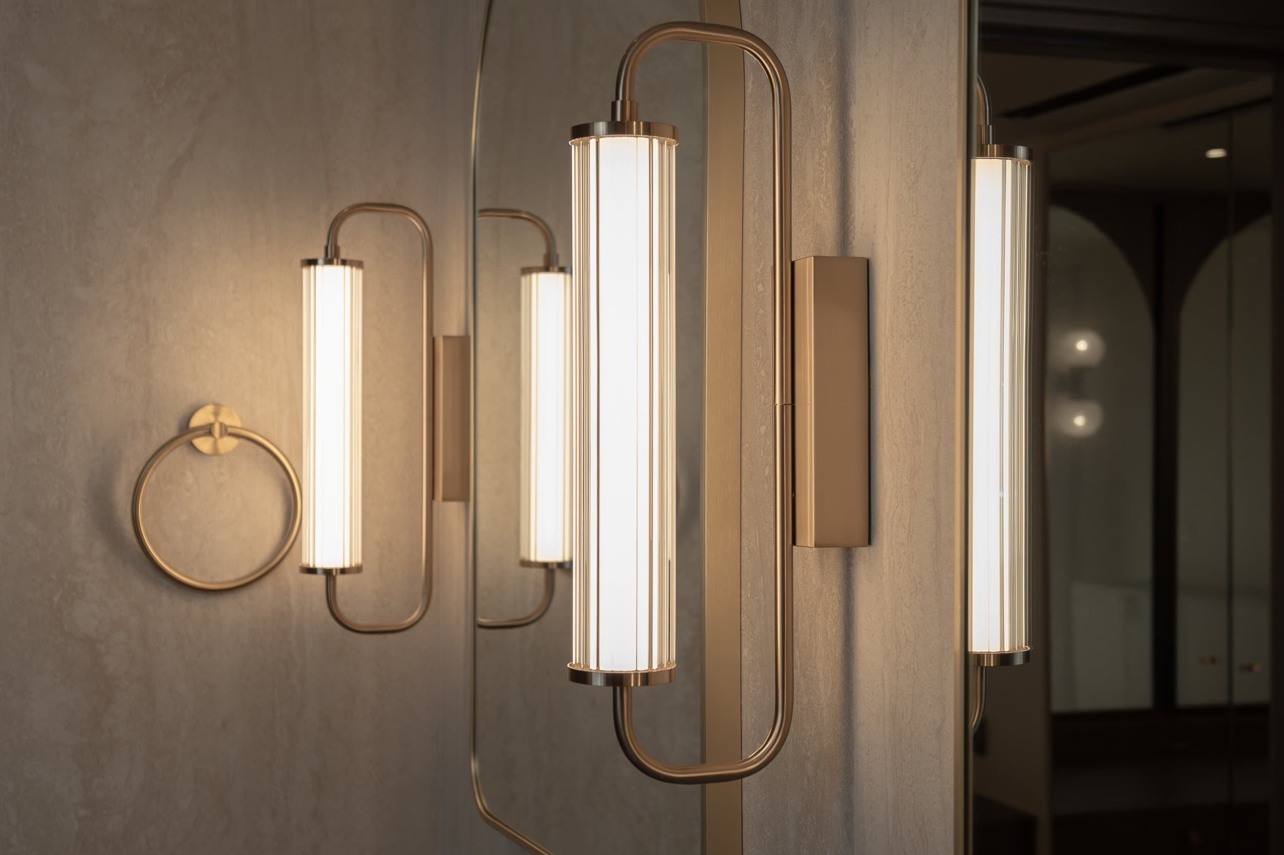 Brushed brass sconces by the vanity mirror