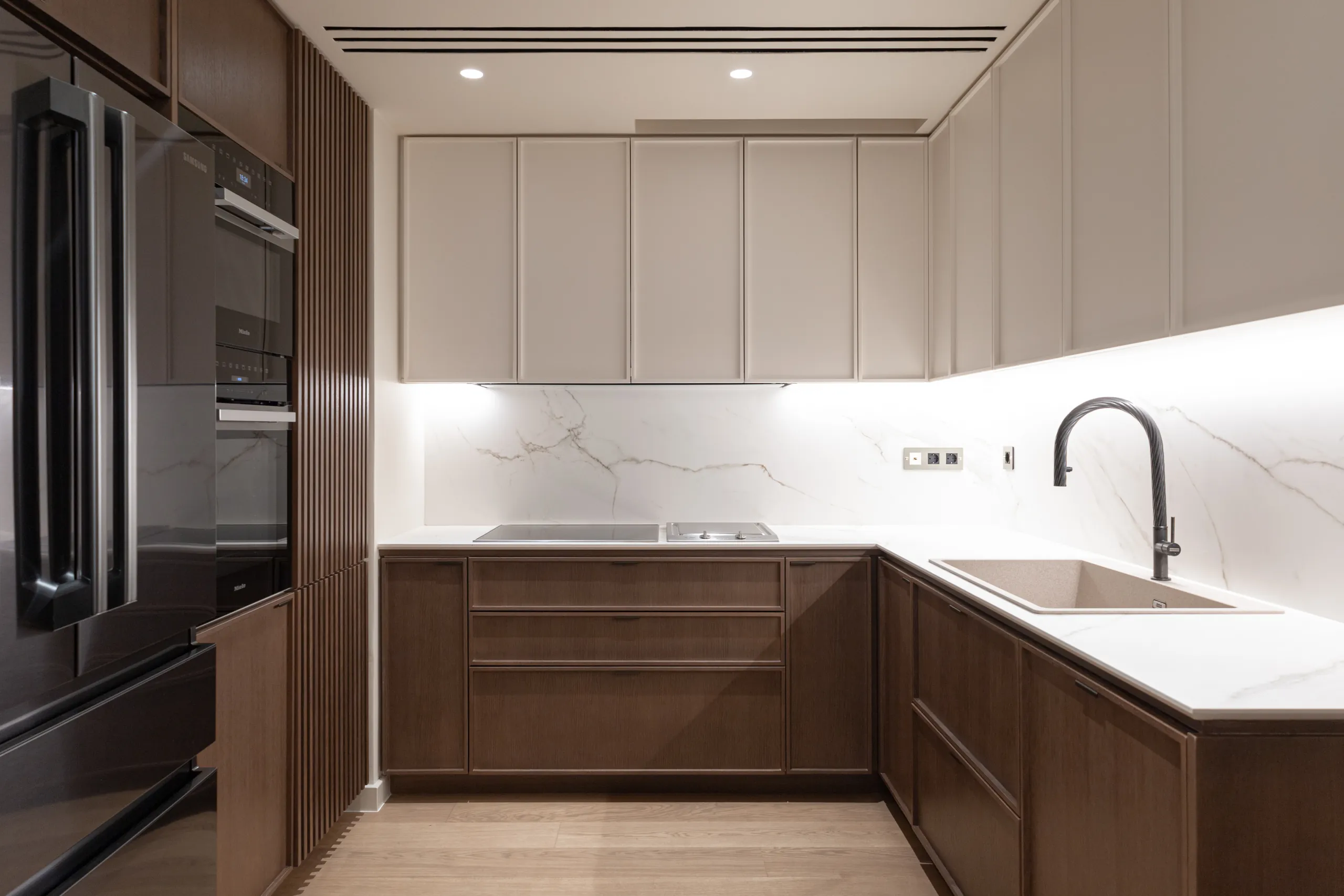 Kitchen with walnut cabinetry and veined marble backsplash