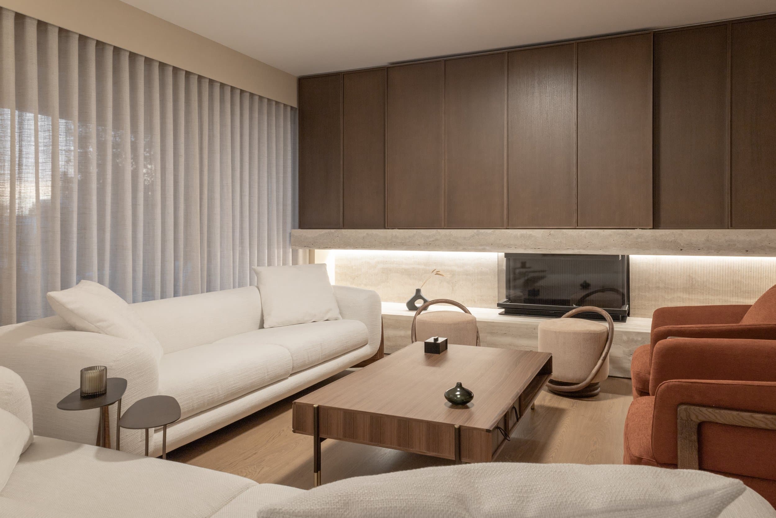 Living area with sheer curtains and walnut paneling