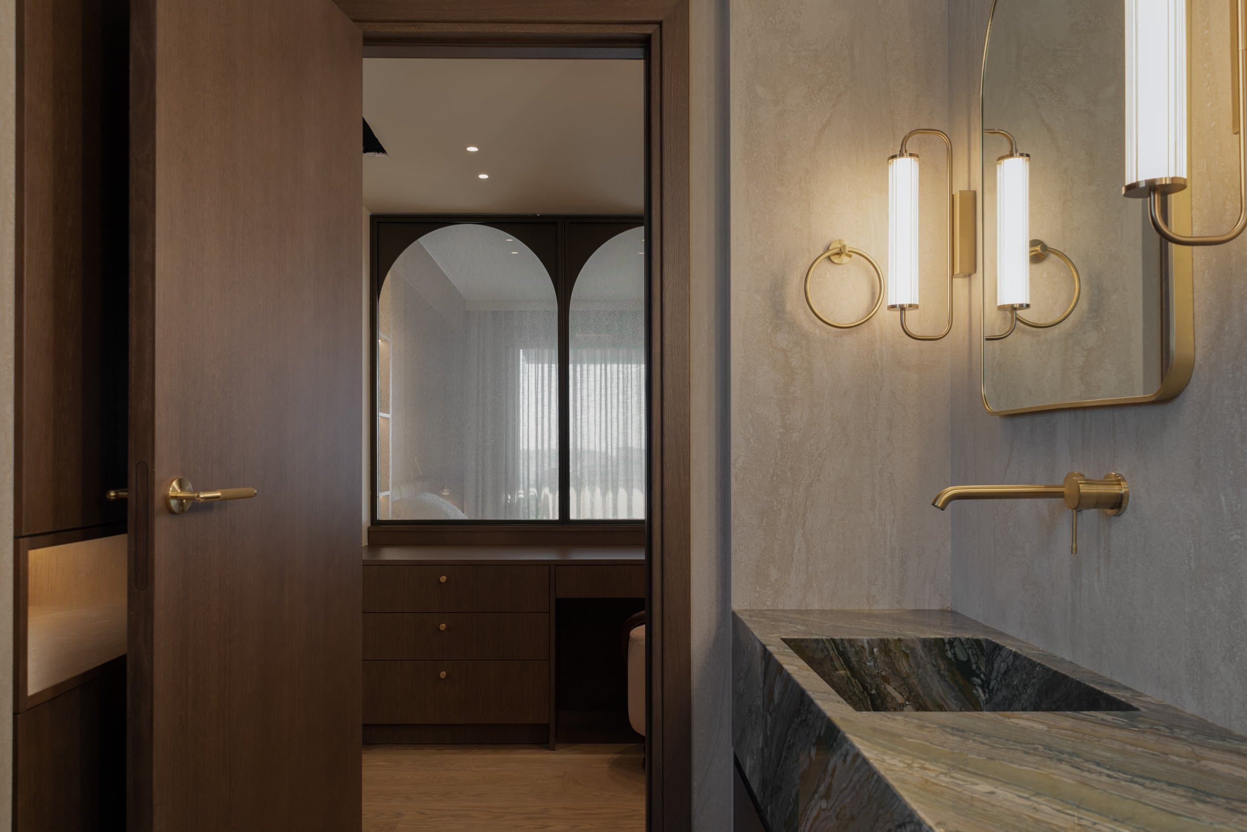 Master bathroom vanity with green stone washbasin and brass fittings